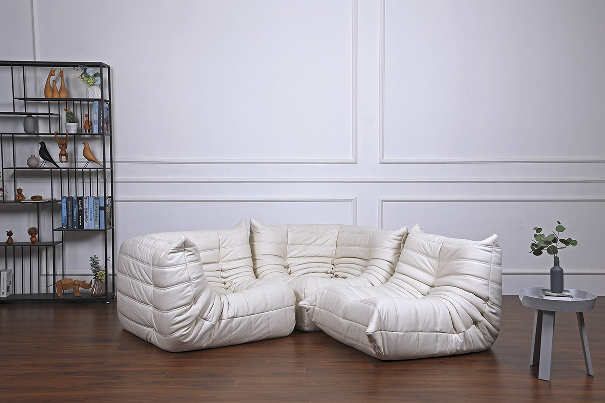 Combination of white aniline leather togo chair without armrests, togo chair with armrests, and a togo corner sofa